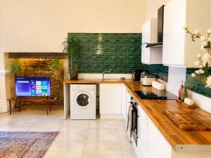 a kitchen with a washer and dryer in it at The Fig Tree in Brecon