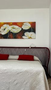a bedroom with a bed with a painting on the wall at A'MA CASA in Modica