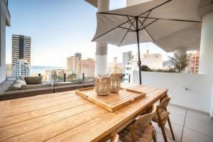 a wooden table with an umbrella on a balcony at Silver Tower 7A in Ifach