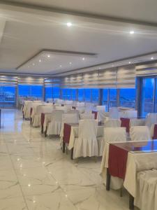 a banquet hall with white tables and white chairs at Bulut Hotel in Pamukkale