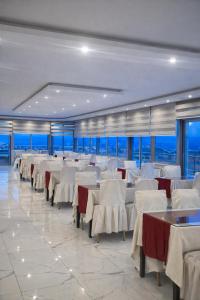 a dining room with white tables and white chairs at Bulut Hotel in Pamukkale +5 photos