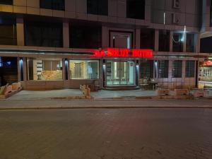 a building with a red neon sign in front of it at Bulut Hotel in Pamukkale