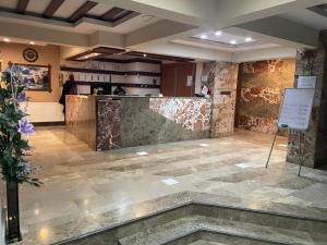 a lobby with a stone floor and a counter at Bulut Hotel in Pamukkale