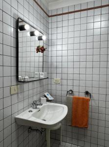 a white bathroom with a sink and a mirror at A'MA CASA in Modica +16 photos