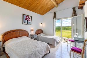 a bedroom with two beds and a window with a view at Gite Four De Mon Père in Salignac Eyvigues +23 photos