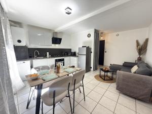 a kitchen and living room with a table and chairs at Le Méli Hyper Centre Proche Cols Stations in Saint-Jean-de-Maurienne