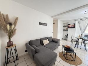 a living room with a couch and a table at Le Méli Hyper Centre Proche Cols Stations in Saint-Jean-de-Maurienne