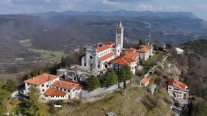 a large building on top of a hill at Guesthouse Rajski okusi Sveta Gora in Solkan