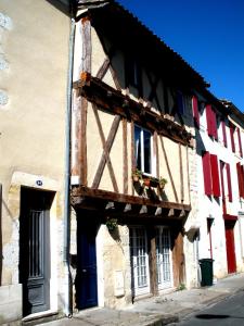 an old building with red and white doors and windows at Les Terraces Sur La Dordogne in Sainte-Foy-la-Grande +6 photos