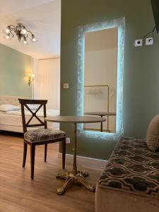 a room with a table and a mirror and a bed at Hôtel D’Artiste in Pierrefontaine-les-Varans