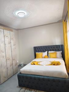 a bedroom with a large bed with yellow pillows at GLOW Suites in Naivasha