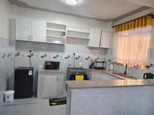 a kitchen with white cabinets and a counter top at GLOW Suites in Naivasha