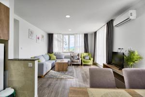a living room with a couch and a tv at Regency Aparthotel Sarajevo in Sarajevo