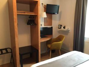 a room with a desk with a computer and a chair at Hotel les voyageurs in Saint-Renan