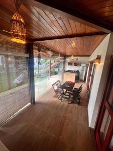a porch with a table and chairs and a chandelier at Rainha do gelo in Barra Grande