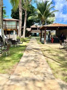 a walking path in front of a resort with palm trees at Rainha do gelo in Barra Grande