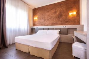 a bedroom with a large white bed in a room at Hotel Helvetia in Lido di Jesolo