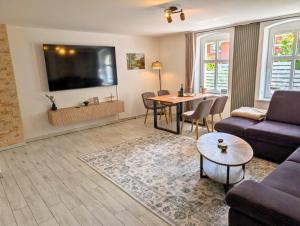 a living room with a couch and a table at Hofidyll Burg - ruhige 75qm FeWo im Zentrum mit Terrasse & Biergarten - bis 6 Personen in Burg