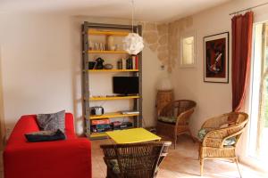 Saint-SiffretにあるA l'Est d'Uzèsのリビングルーム(赤いソファ、椅子付)