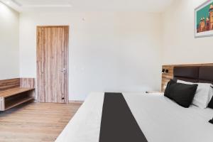a bedroom with a black and white bed and a wooden door at Hotel O Hotel Shiv Lok in Kaliānpur +21 photos