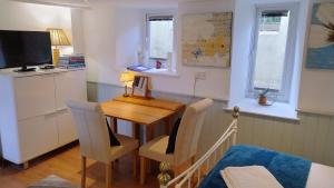 a room with a table and chairs and a television at The Studio at St Cleer in Chippenham