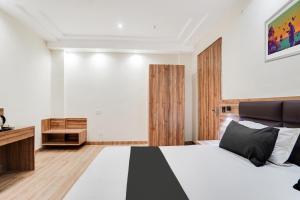 a bedroom with a black and white bed and wooden floors at Hotel O Hotel Shiv Lok in Kaliānpur
