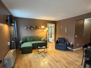 a living room with a green couch and a chair at Woodford Rest in Woodford