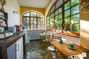 a kitchen with a table and chairs and windows at Appartamenti La Menaresta quiet & relax near Bellagio in Magreglio