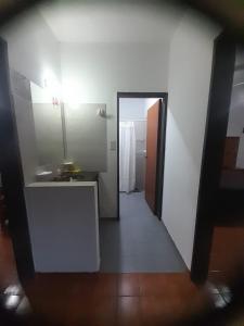 a hallway to a bathroom with a sink and a mirror at tabaquillo in Villa Cura Brochero