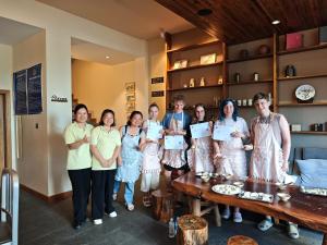 a group of women standing in a room with certificates at Guilin cozy mountain retreat in Guilin