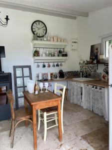 a kitchen with a table and a clock on the wall at Villa la Roma in Aix-en-Provence