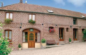 a brick building with a bench in front of it at le tilleul in Caumont