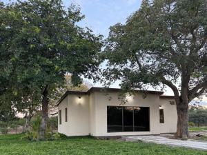 a small white house with a large window at Watupa Chalets in Rundu