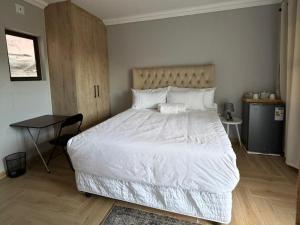 a bedroom with a large white bed and a table at Watupa Chalets in Rundu
