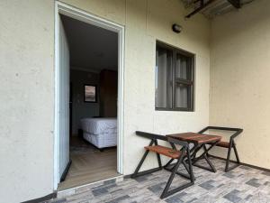 a patio with a table and a bed in a room at Watupa Chalets in Rundu