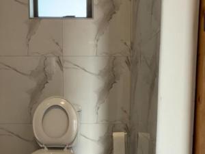 a bathroom with a toilet with a marble wall at Watupa Chalets in Rundu +31 photos