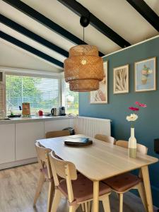 a dining room with a wooden table and chairs at De Zeebries in Warmenhuizen