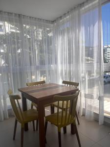 a dining room with a table and chairs and a window at Apto familiar, 150mts do mar, completo e aconchegante em Palmas in Governador Celso Ramos