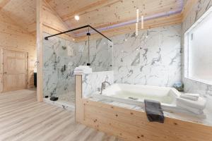 a bathroom with a bath tub in a wooden house at Hilltop Haven Treehouse in Cornelia +67 photos