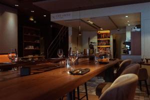 a large wooden bar in a restaurant with wine glasses at Hotel les voyageurs in Saint-Renan