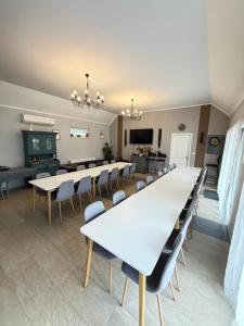 a large room with white tables and chairs at Ulics vendégház II in Zalacsány