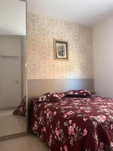 a bedroom with a bed and a mirror at Apto familiar, 150mts do mar, completo e aconchegante em Palmas in Governador Celso Ramos