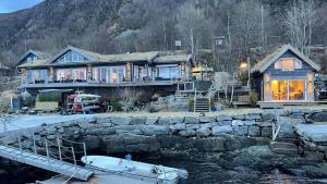 a large house with a boat in front of it at Småstranda 7B Boathouse in Store Teisten +6 photos