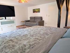 a bedroom with a large bed and a couch at Hofidyll Burg - ruhige 75qm FeWo im Zentrum mit Terrasse & Biergarten - bis 6 Personen in Burg