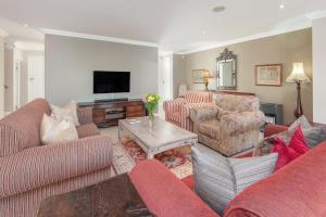a living room with two couches and a tv at Spatalla Holiday Homes in Kleinmond