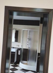 a reflection of a bathroom with a refrigerator at Alfa Mall in Sibiu
