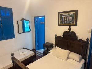 a bedroom with two beds and a blue door at Pousada santa rita in Paraty