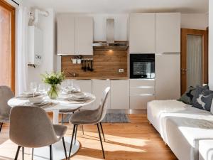 a kitchen and a living room with a table and chairs at Siera Essence Apartments - Comfort e Relax a Sappada in Sappada