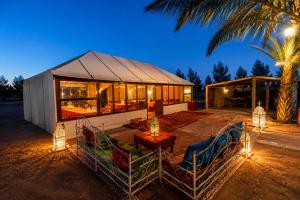 a house with chairs and a table in front of it at Luxury Sahara Desert Glamping Experience in Merzouga in Merzouga