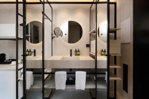 ein Badezimmer mit Waschbecken und zwei Spiegeln in der Unterkunft Olivia Lisboa Hotel in Lissabon + 67 Fotos
